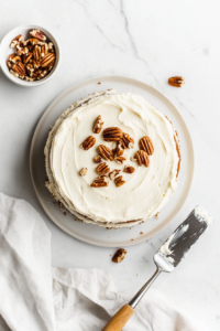 frosting-the-cake-and-topping-it-generously-with-chopped-pecans