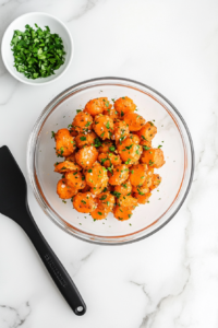 garnishing-roasted-carrots-with-fresh-cilantro-before-serving-on-a-white-plate