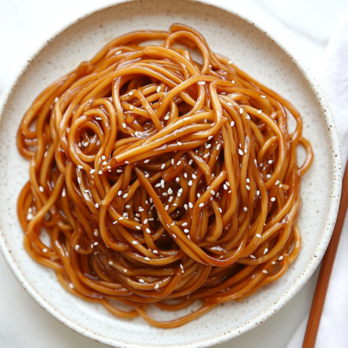hibachi-noodles-tossed-in-spicy-sauce-served-in-four-bowls-topped-with-white-sesame-seeds-2
