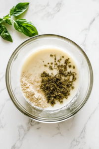 This image shows biscuit dough divided into rounds and flattened on floured wax paper, on a white marble cooktop.