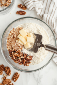 This image shows the ingredients for the crisp topping—brown sugar, flour, butter, and oats—being mixed into a crumbly texture.