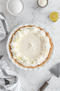 This image shows creamy coconut and softened cream cheese being mixed together in a bowl, creating the rich and tropical filling for the pina colada pie.