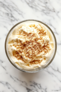 This image shows milk, flour, and vanilla being gently mixed into a bowl of cream cheese to create a smooth and creamy filling.