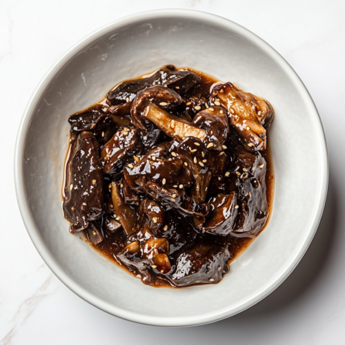 This image shows a beautifully plated dish of roasted carrots glazed in a shiny sauce and topped with fresh cilantro leaves for a burst of color and flavor.