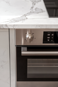 This image shows a silver digital oven display set to 350°F, viewed from above on a white marble countertop.