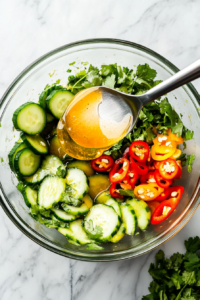 This image shows the creamy avocado dressing being poured over the fresh salad ingredients before being gently tossed together.
