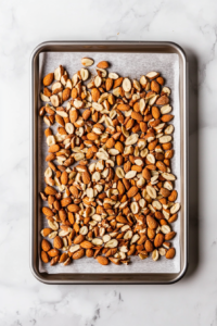 This image shows nuts roasting in the oven until golden brown and aromatic, creating the perfect crunchy topping for the salad.