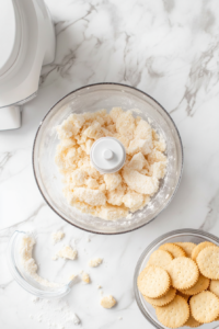 shortbread-biscuits-crushed-into-fine-crumbs-using-rolling-pin-in-clear-plastic-bag-on-kitchen-counter