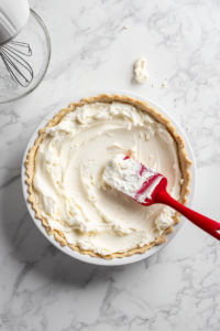 smoothing-cream-cheese-mixture-into-crust-for-rich-filling