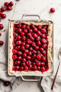 spooning-cherry-pie-filling-over-dough-layer