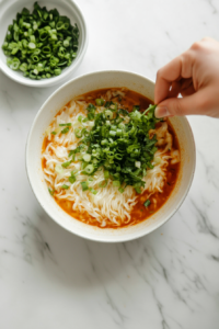 sprinkling-green-onions-over-noodles-for-color-and-crunch