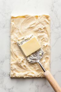 the-buttered-and-filled-dough-being-tightly-rolled-into-a-log-before-slicing