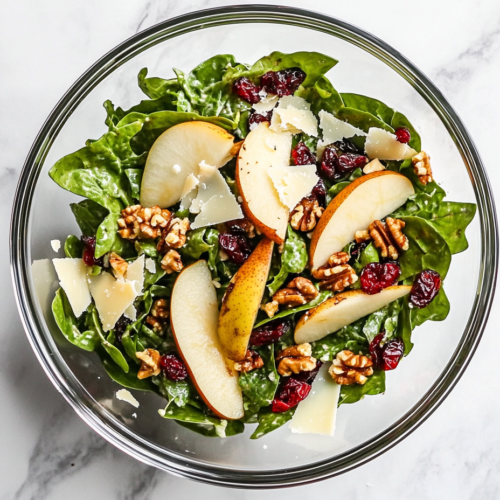 vibrant-autumn-salad-with-sliced-pears-mixed-greens-candied-pecans-and-goat-cheese-in-a-white-serving-bowl