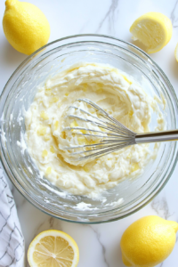 This image shows the lemon garlic aioli mixture being whisked vigorously to emulsify the ingredients into a thick, creamy consistency