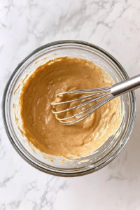 This image shows all the ingredients being gently mixed together until the pancake batter is smooth and lump-free.