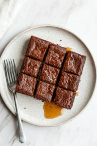 This image shows the fully cooled Parkin cake being carefully wrapped in parchment paper, a crucial step to develop its deep, rich flavors over time.