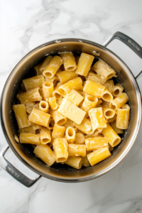 boiling-rigatoni-pasta-large-stainless-steel-pot-on-white-marble-cooktop