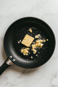 butter-and-garlic-sauteing-in-black-skillet-on-white-marble-2