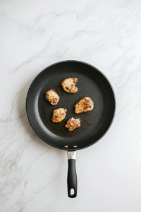 cooking-seasoned-chicken-in-black-skillet-for-keto-alfredo