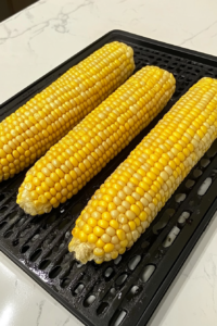corn-ears-on-grill-away-from-heat-over-white-marble