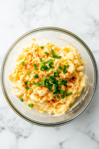 deviled-egg-pasta-salad-garnished-in-glass-bowl