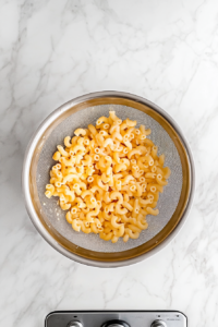 draining-elbow-macaroni-in-colander-on-white-marble