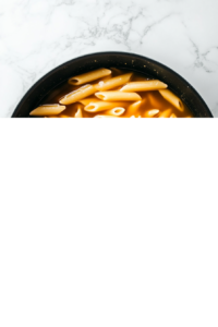 dry-penne-in-chicken-broth-black-skillet-marble-cooktop