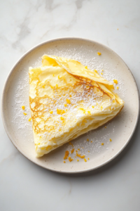 finishing-touch-dusting-crepes-with-powdered-sugar-and-zest