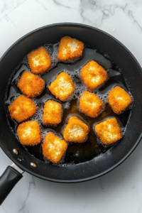 frying-tofu-nuggets-in-black-skillet-until-crispy-golden