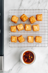golden-tofu-nuggets-drained-on-rack-with-vegan-dipping-sauce