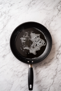 heating-vegetable-oil-in-black-skillet-for-mushroom-frying