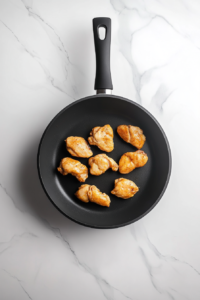 meat-thermometer-checking-chicken-in-black-skillet-on-white-marble-for-keto-alfredo