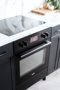 This image shows a black oven with its digital display set to 350°F on a white marble countertop, with no additional items or ingredients visible.