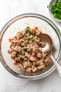 pressing-tuna-mixture-into-paste-in-glass-bowl