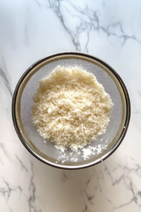 rinsed-rice-drained-in-colander-on-white-marble