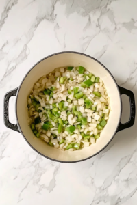 sauteed-onion-bell-pepper-garlic-in-dutch-oven-on-white-marble