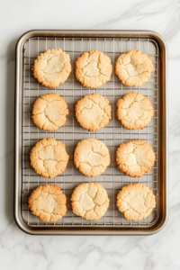 shortbread-cookies-cooling-on-baking-sheet-on-wire-rack-over-white-marble