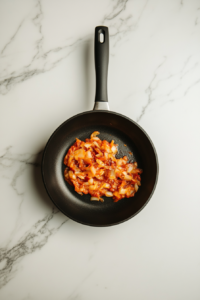 tomato-puree-and-passata-in-skillet-with-onions-on-white-marble