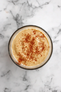 This image shows a smooth custard mixture in a glass bowl made from milk, sugar, eggs, cinnamon, and vanilla, ready to be poured over the bread.