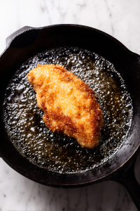 chicken-frying-in-oil-in-black-cast-iron-skillet-2