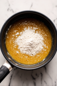 adding-flour-and-taco-seasoning-to-melted-butter-in-black-saucepan