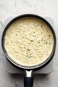 adding-sour-cream-green-chiles-to-enchilada-sauce-in-black-saucepan-2