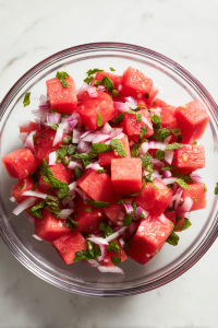 adding-watermelon-shallots-mint-to-glass-bowl-top-down