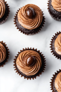 This image shows the final stage of cupcake assembly with chocolate ganache filled centers, mocha frosting, espresso bean topping, and cocoa dusting.