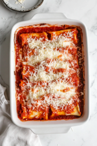 baking-dish-lasagna-rolls-topped-with-tomato-sauce-mozzarella-white-marble