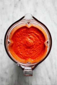 blended-masala-sauce-in-clear-blender-jar-on-white-marble