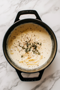 broth-cream-spices-mixed-in-black-dutch-oven