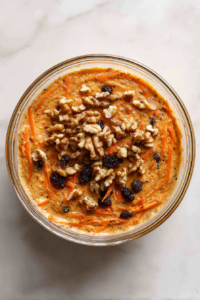 carrot-raisin-walnut-mixture-folded-into-batter-in-glass-bowl