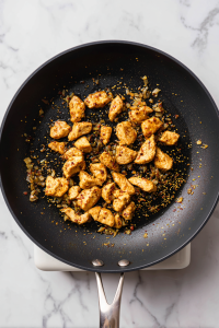 chicken-pushed-aside-with-well-in-center-black-skillet