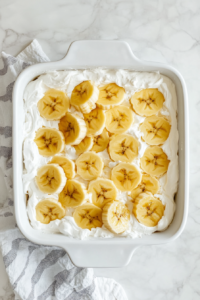 cool-whip-layer-spread-over-fruit-on-banana-split-cake